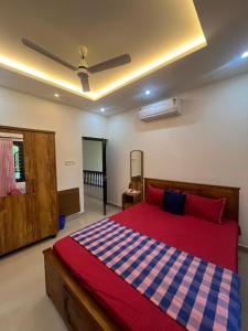 a bedroom with a bed with a red and blue checkered blanket at Manasam Homes Near To IIM & NIT - kOZHIKODE in Kunnamangalam