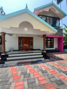 a house with a staircase in front of it at Manasam Homes Near To IIM & NIT - kOZHIKODE in Kunnamangalam
