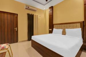 a bedroom with a large bed and a chair at Amba heritage house in Prayagraj