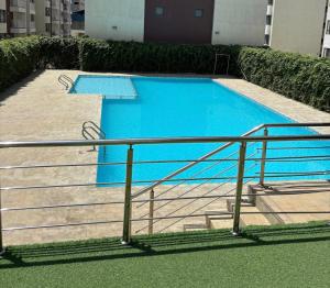 a large blue swimming pool with stairs next to a building at Naisolas place in Marimbeti +7 photos