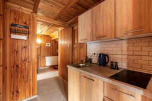 a kitchen with wooden cabinets and a sink at Nostalgia noclegi in Olsztyn