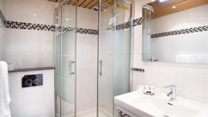 a bathroom with a glass shower and a sink at Hôtel De Venise in Paris