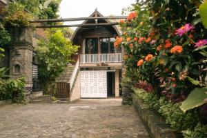 an entrance to a building with a gate and flowers at Villa AMPO unique Gazebo Flat in Munggu