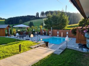 a backyard with a swimming pool and a fence at Pension Altvogtshof in Eisenbach