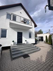 a white house with a dog sitting on a balcony at SeaLine Odessa in Kryzhanivka