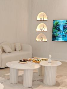 a living room with a couch and a table with food on it at Athens Resort in Madīnat an Nahḑah