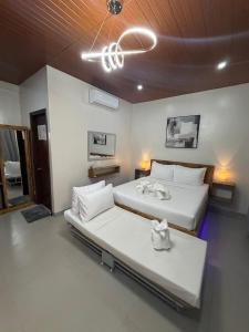 a bedroom with two beds and a chandelier at Emman's Guest House in Anda