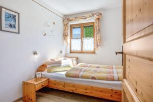 a bedroom with a wooden bed and a window at Ferienwohnung am Schusterhof in Wonneberg