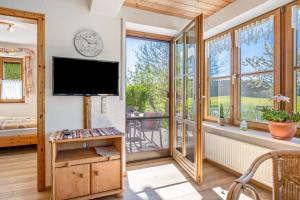 a living room with a flat screen tv and windows at Ferienwohnung am Schusterhof in Wonneberg