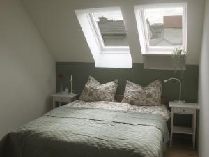 a bedroom with a bed with two windows at Studio LEOPOLD LEIBNITZ in Leibnitz +26 photos