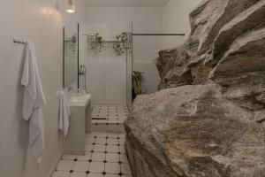 a bathroom with a shower and a large rock at Oikia Classic House in Old Town Kavala in Kavála