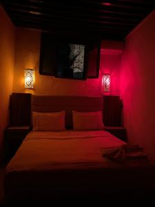 a bedroom with a bed with two lights on it at House andalous in Fez
