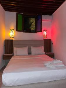 a bedroom with a large white bed with two lights at House andalous in Fez