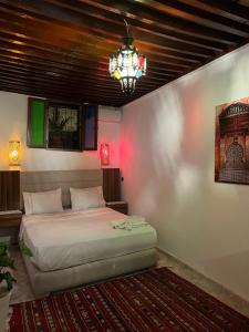 a bedroom with a bed and a chandelier at House andalous in Fez +49 photos