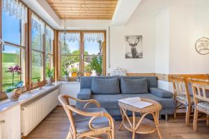 a living room with a blue couch and chairs at Ferienwohnung am Schusterhof in Wonneberg