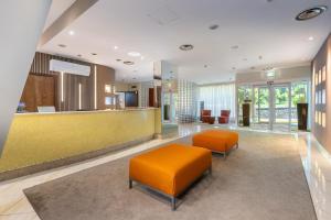 a lobby with two orange chairs and a waiting room at Aston Hotel in Pino Torinese