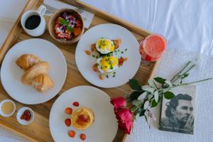 a tray with three plates of breakfast food on it at Alami Apartment Seminyak in Seminyak