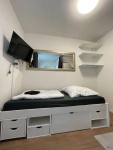 a bedroom with a bed with a tv on the wall at Paulibude in Hamburg