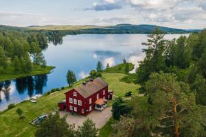 an aerial view of a large red house on a lake at THE LODGE Torsby in Torsby