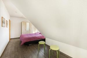a bedroom with a purple bed and two stools at Ferienwohnung Im Tal Olsberg in Olsberg