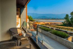 a balcony with a table and chairs and a view at Nirvanika Wellness Luxury Apartments in Rishīkesh