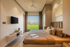 a bedroom with a large bed with a large window at Nirvanika Wellness Luxury Apartments in Rishīkesh