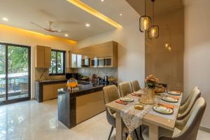 a kitchen and dining room with a table and chairs at Nirvanika Wellness Luxury Apartments in Rishīkesh