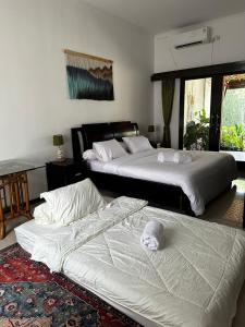 two beds in a hotel room with two bedsitures at Roemah Uli Cirebon in Cirebon