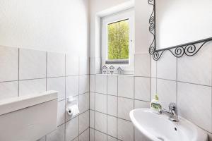 a white bathroom with a sink and a mirror at Ferienwohnung Im Tal Olsberg in Olsberg