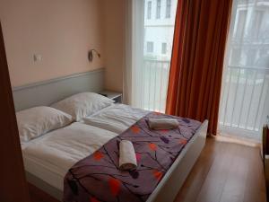 a bedroom with a bed with shoes on it at Főtér Panzió in Baja +83 photos