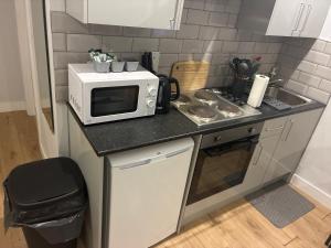 a small kitchen with a microwave on a counter at The Parade, Market Square room 3 in Northampton +5 photos