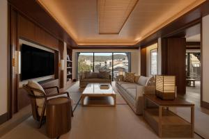 a living room with a couch and a tv at Capella Kyoto in Kyoto