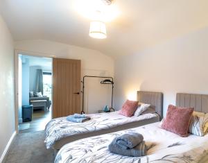 two beds sitting next to each other in a room at The Calf House in Sibbertoft