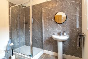 a bathroom with a shower and a sink and a mirror at The Calf House in Sibbertoft