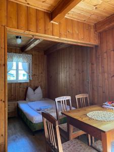 a room with a bed and a table with chairs at Chalupa Něža in Petrovice