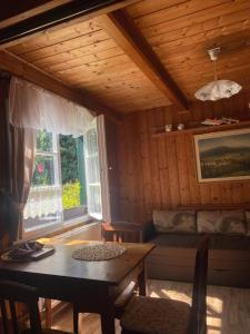 a room with a table and a couch and a window at Chalupa Něža in Petrovice