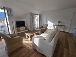 a living room with a white couch and chairs at Casa Giardino Vista Mare in Ventimiglia