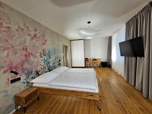 a bedroom with a bed and a tv on a wall at Hotel U Feldů in Klimkovice