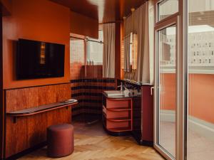 a bathroom with a sink and a tv on the wall at The Companion Vienna in Vienna