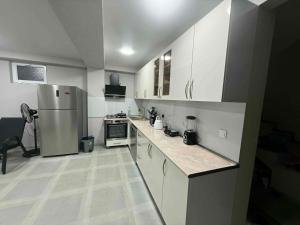 a kitchen with white cabinets and a stainless steel refrigerator at Grigoleti Royal in Grigoleti