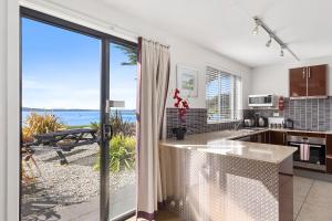 a kitchen with a view of the ocean at Beachfront Apartment Blackmans Bay in Kingston Beach
