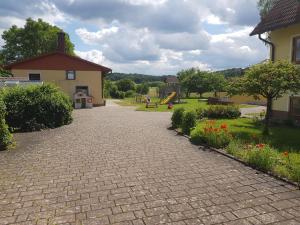 un vialetto di mattoni che conduce a un parco giochi con uno scivolo di Fritzerhof a Gössweinstein