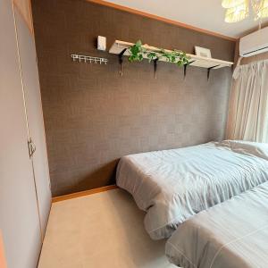 a bedroom with a bed with a plant on the wall at ブルク井尻 Brug ijiri in Itazuke