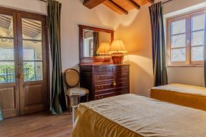 a bedroom with a bed and a dresser and a mirror at Villa privata in Maremma Tuscany fontanile & wifi in Montorgiali +42 photos