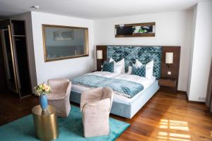 a hotel room with a bed and two chairs at Luxury Boutique Hotel Iris Porsche in Mondsee