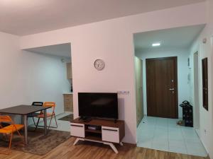 a living room with a tv and a table and a dining room at Sunny Pine Apartment Mavrovo in Mavrovo