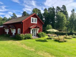 a red barn with a table and an umbrella at THE LODGE Torsby in Torsby