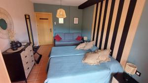 a bedroom with two twin beds and a couch at El Mirador de Adrial in Ladrillar
