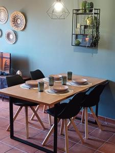 a wooden table with chairs and plates on it at El Mirador de Adrial in Ladrillar