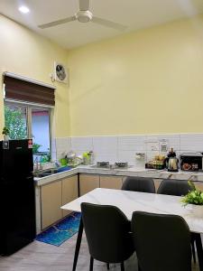 a large kitchen with a table and chairs in it at dayah homestay in Siputih